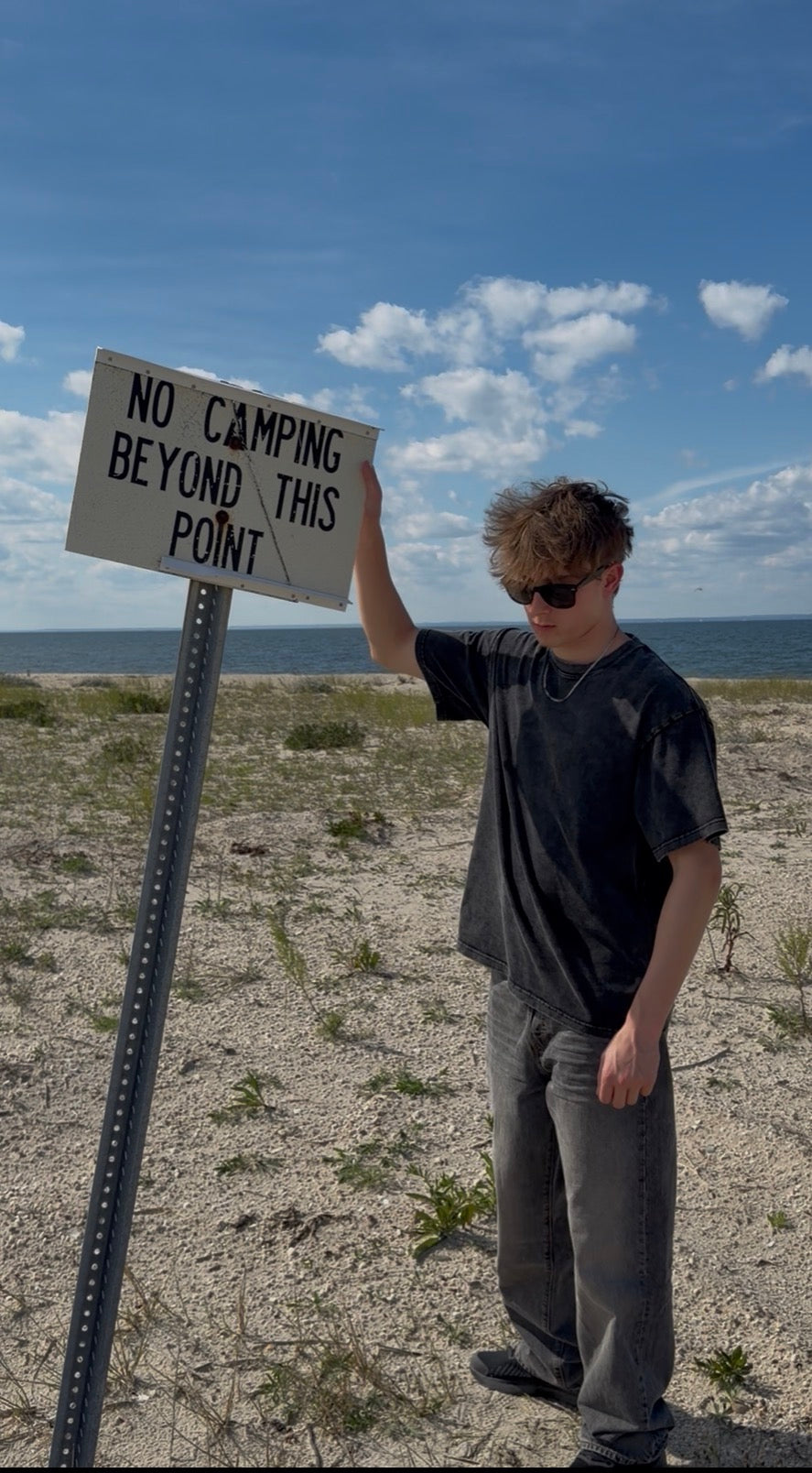 BeyondCure beach campaign front portrait beside the Beyond This Point sign